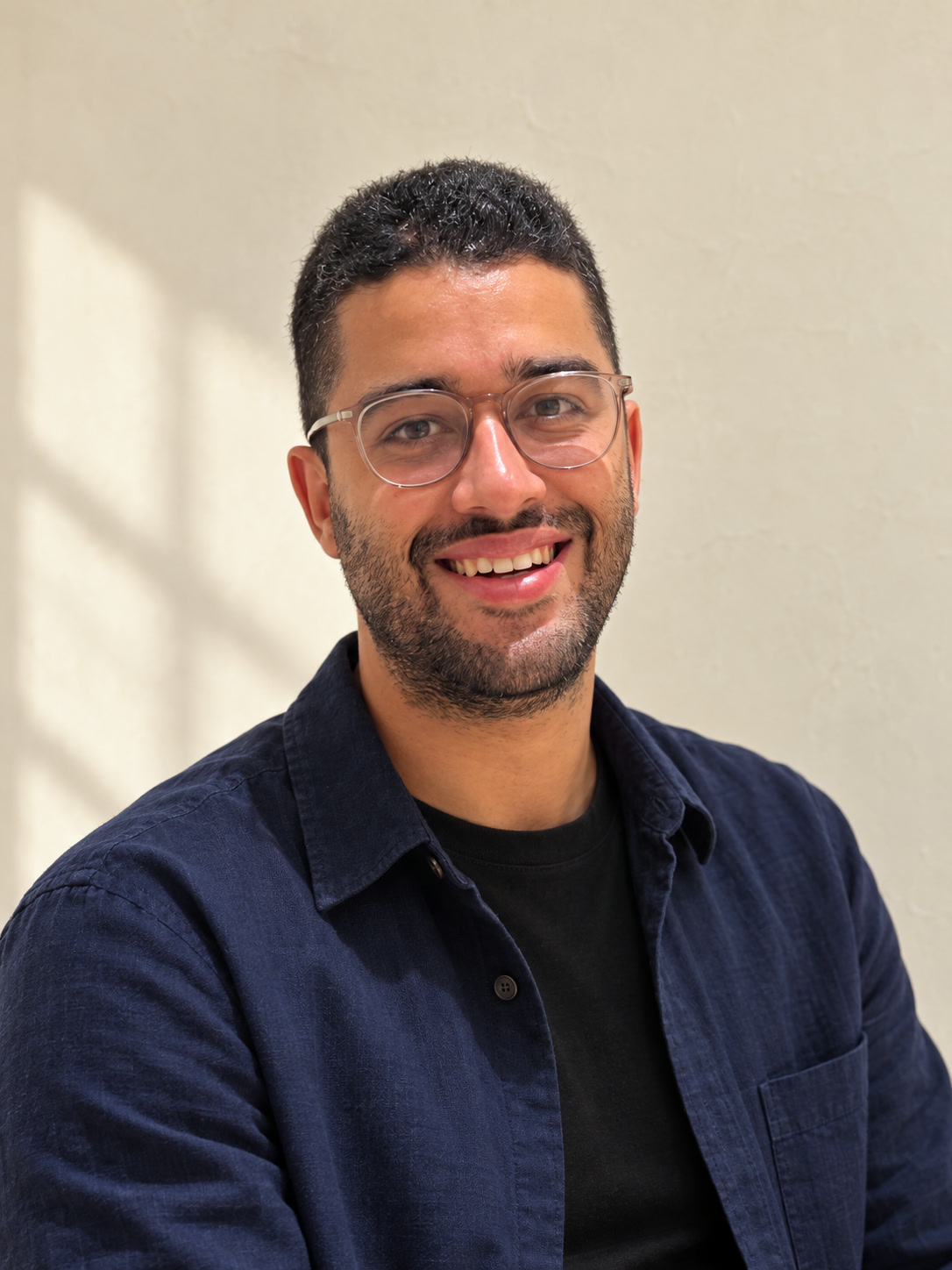 Taieb Bendai smiling at the camera in a navy overshirt.